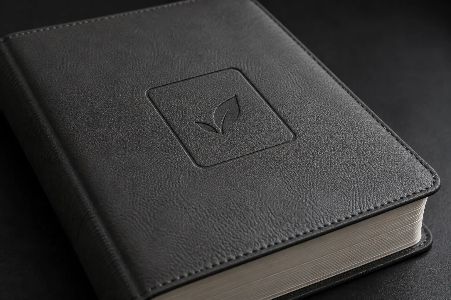 Recessed abstract leaf motif debossed into a charcoal leather-like Bible cover