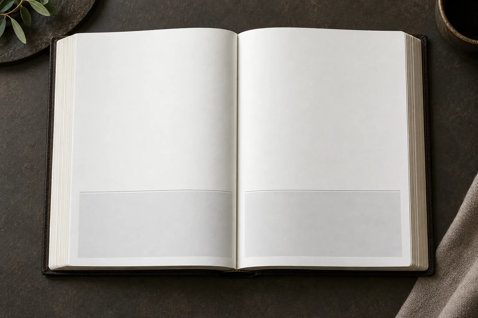 Open blank book spread with pale lower note-layout panels