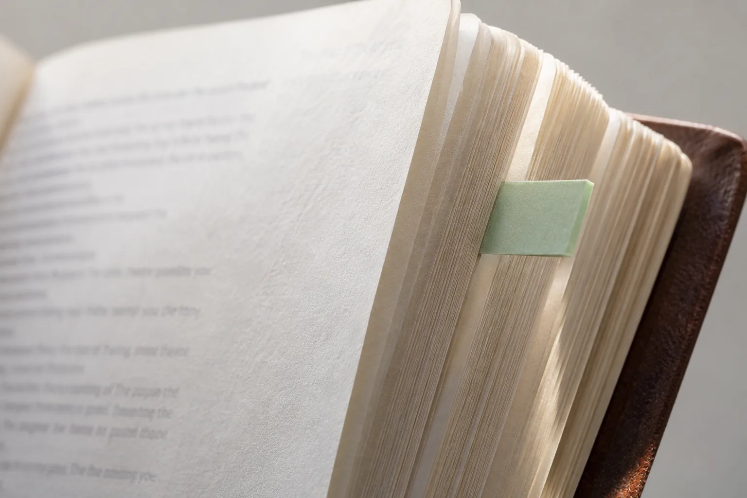 Close view of a green adhesive tab folded over a single Bible page